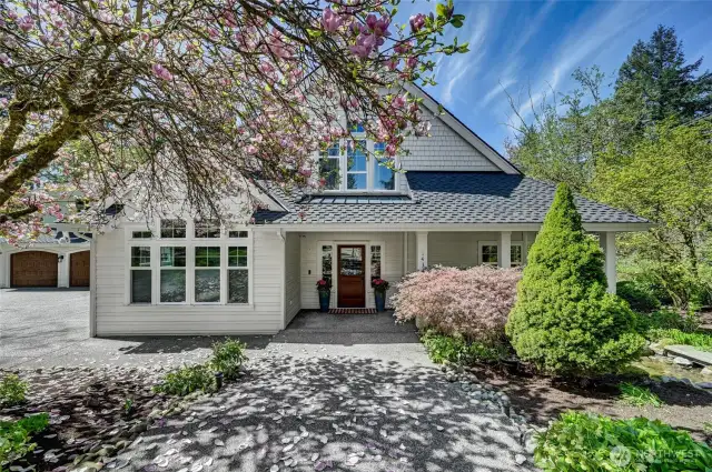 The gracious entry is set off with beautiful gardens. Presidential comp and metal roof 50 year roof installed in 2019. New cement plank siding installed on the front of the house.