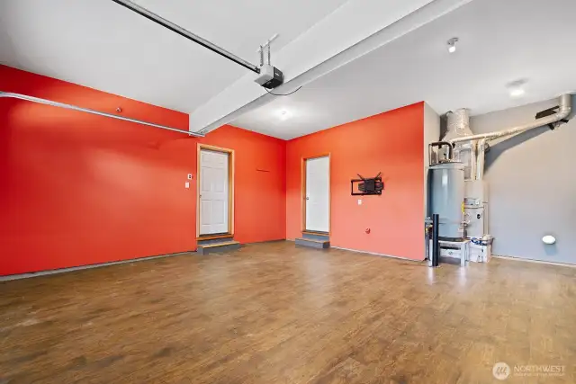 Garage with engineered hardwood flooring.