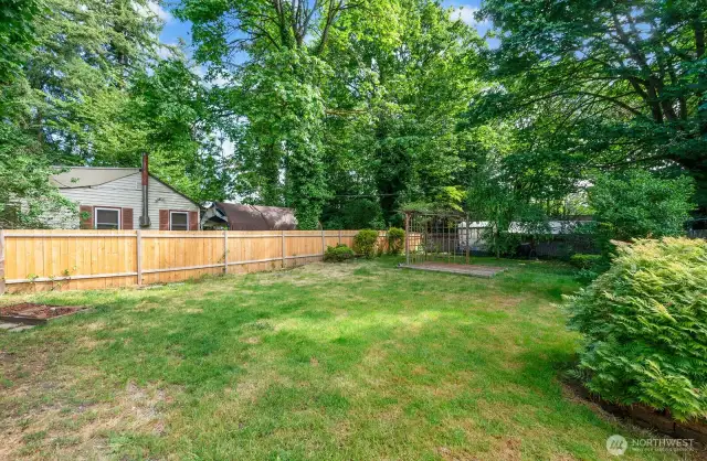 Flat backyard that is fully fences.