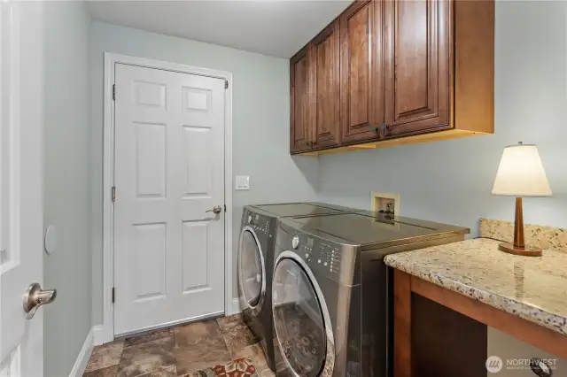 Laundry off the garage with cabinets that match the kitchen ones.