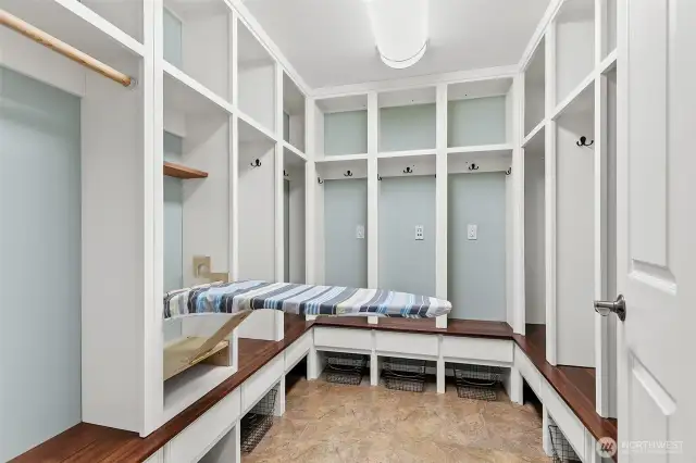 A rare gem, an elegant multiple cubby mud room for organization, equipped with an ironing center right across from the main floor utility room!