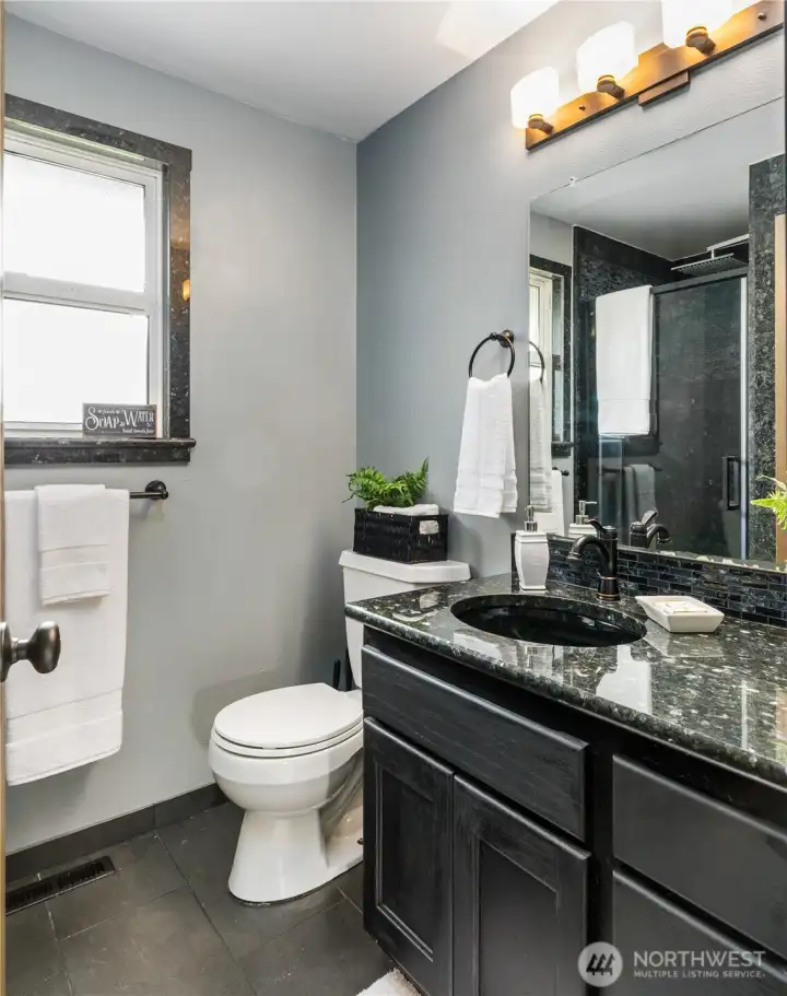 Primary bath also has granite countertops and a full granite shower.  There is also a linen closet behind the bathroom door