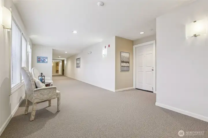 Front door to condo #207 with wide hallways, light and bright.