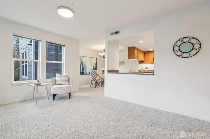 Living room is open to the dining room with countertop space for decorating or placing food and drink for entertaining