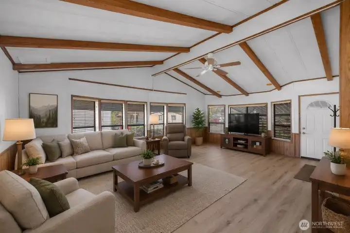 *Virtually staged* Grand livingroom with vaulted ceilings and new luxury vinyl plank flooring that flows seamlessly throughout the home.