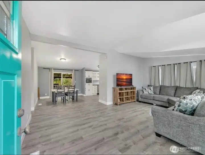 Inviting front entry leads to a light-filled open layout with attractive vaulted ceiling and expansive south-facing windows, offering beautiful natural light throughout the day.