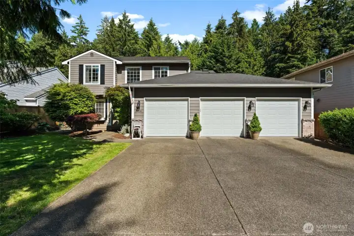 Welcoming exterior with mature landscaping, expansive driveway, and three-car garage. Welcoming exterior with mature landscaping, expansive driveway, and three-car garage.
