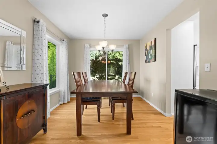 Dining area features hardwood flooring and large windows overlooking the surrounding greenery. Dining area features hardwood flooring and large windows overlooking the surrounding greenery.