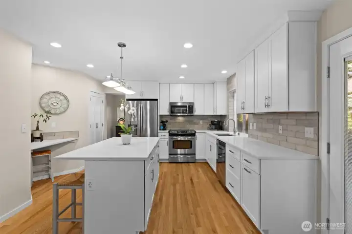Welcoming kitchen with expansive island seating and abundant workspace for gathering and entertaining. Welcoming kitchen with expansive island seating and abundant workspace for gathering and entertaining.