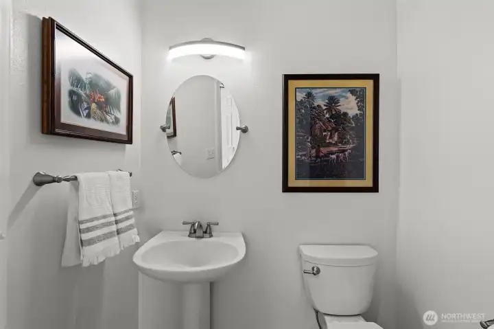 Main-level powder room with pedestal sink and updated lighting fixture. Main-level powder room with pedestal sink and updated lighting fixture.