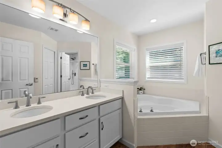 Primary en suite features dual-sink vanity, soaking tub, and separate shower area. Primary en suite features dual-sink vanity, soaking tub, and separate shower area.
