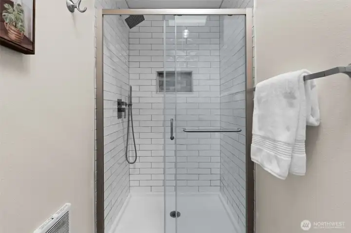 Contemporary walk-in shower featuring subway tile finishes and modern fixtures. Contemporary walk-in shower featuring subway tile finishes and modern fixtures.