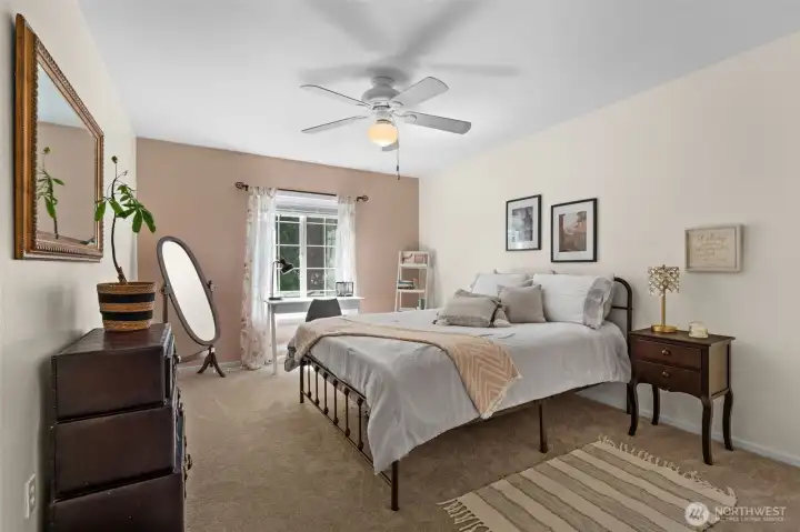 Spacious bedroom featuring plush carpet, large window, and space for a desk or reading area. Spacious bedroom featuring plush carpet, large window, and space for a desk or reading area.