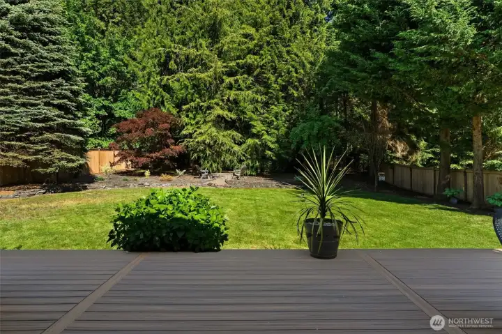Backyard retreat with deck access, manicured lawn, and peaceful wooded backdrop. Backyard retreat with deck access, manicured lawn, and peaceful wooded backdrop.