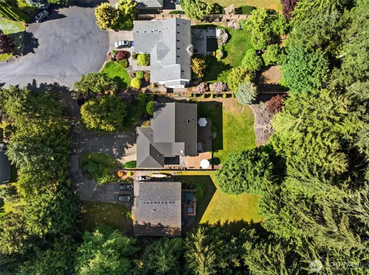 Aerial view showcasing the expansive lot, mature landscaping, and surrounding natural greenery. Aerial view showcasing the expansive lot, mature landscaping, and surrounding natural greenery.