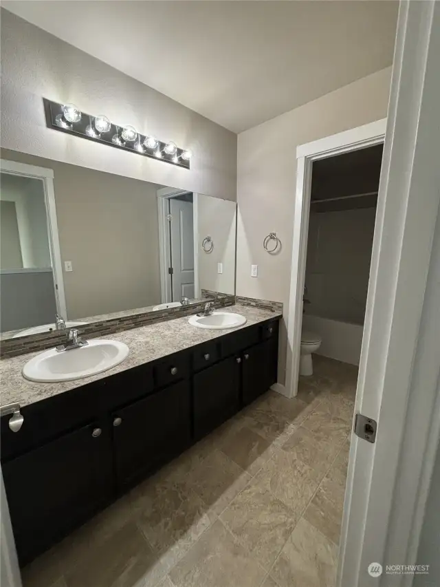 Main bathroom with double sinks & tub/shower