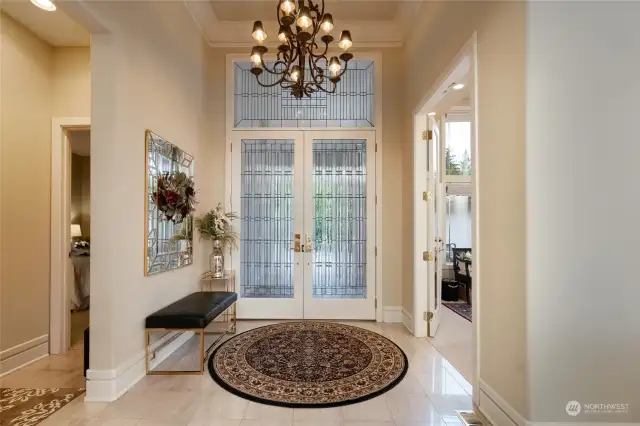 Front entry features custom beveled glass front doors and marble tile.
