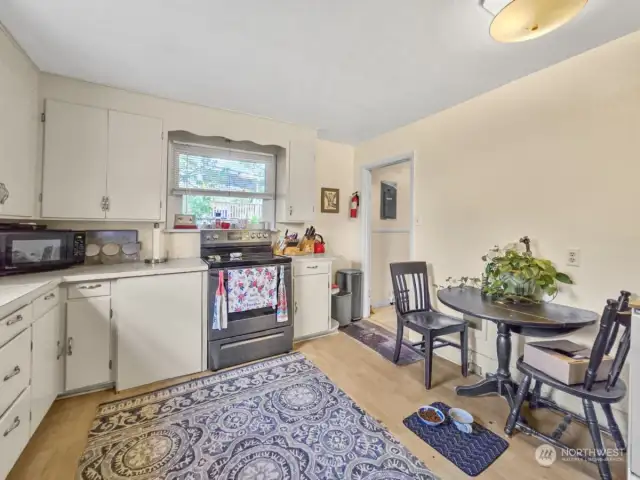 The eat-in kitchen features two windows that fill the space with natural light, enhancing the inviting atmosphere. It has functional wood cabinets and comes complete with stainless steel appliances that will stay with the home, making it a stylish and functional area for meal preparation and dining