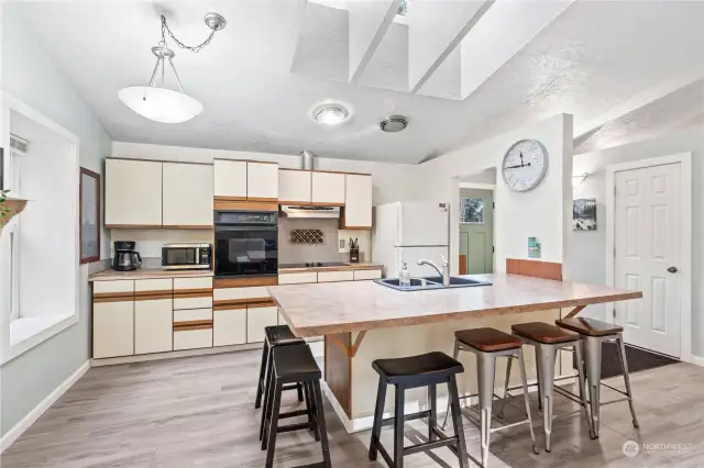 Kitchen w/Peninsula for lots of Seating!  Vaulted Ceilings, Skylights and Light Cabinetry keep the space living large!