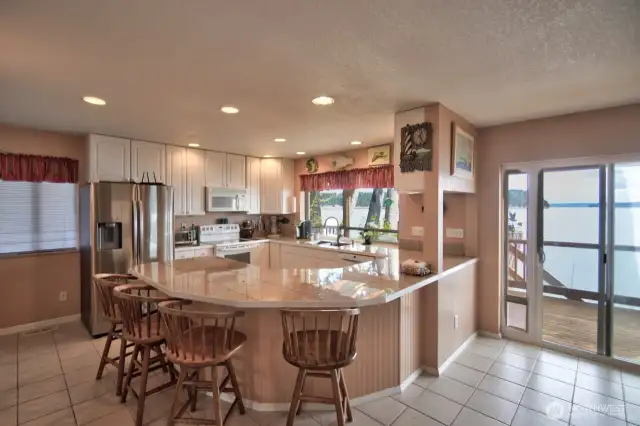 Breakfast bar and kitchen open onto a covered deck for entertaining rain or shine.