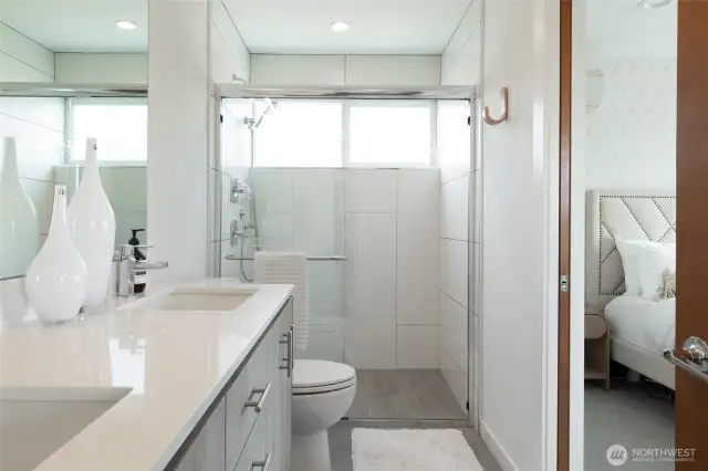The primary bath boasts a spa-like walk-in shower and a sleek double vanity, combining luxury and functionality for your daily routine.
