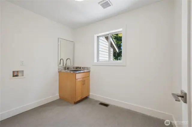 Multi-purpose utility space on the main floor for laundry, mudroom, or extra storage.
