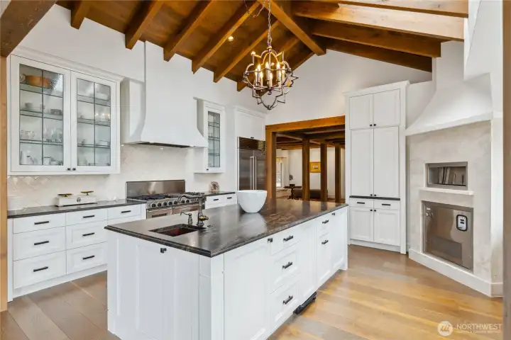 Custom glass-front cabinetry adds refinement and display potential, complementing bespoke millwork throughout the kitchen.  The amount of counter space and abundant storage can accommodate multiple chefs.