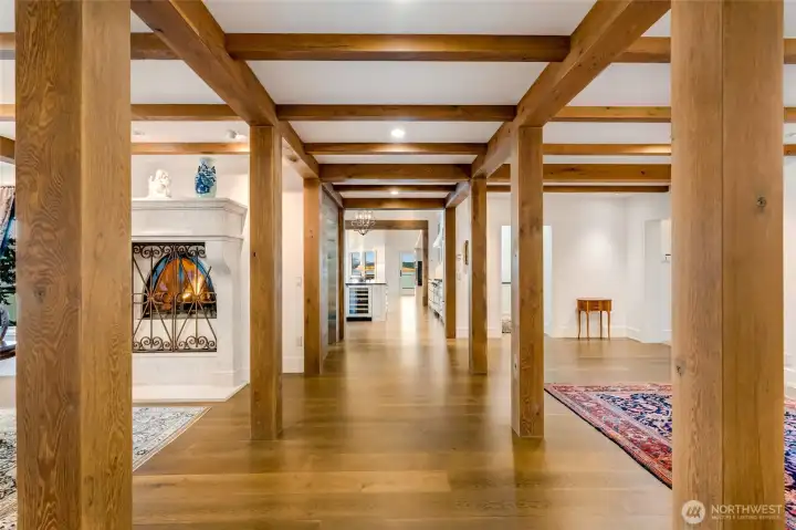 A striking hallway between the dining room and the gallery is framed by reclaimed oak beams, blending warmth with architectural character.