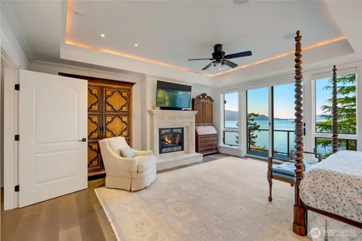 The private wing consists of the primary bedroom is a true retreat with a fireplace, expansive windows, deck, and sweeping views that make the water feel within reach.