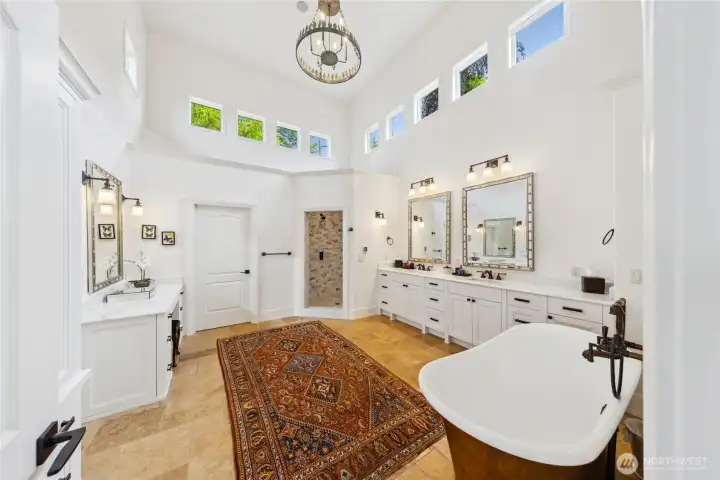 The spa-inspired bath features an English copper soaking tub, radiant floor heat (which is throughout the home), a spacious walk-in shower, and a chandelier engineered to lower for easy care.
