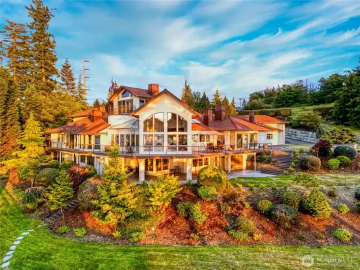 The residence is designed to embrace its setting, with expansive windows and tiered patios that connect seamlessly to the landscaped grounds.