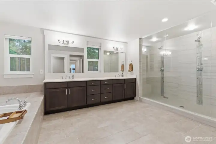 Oversized shower with double heads, double sinks, private toilet area, and plenty of floor space.