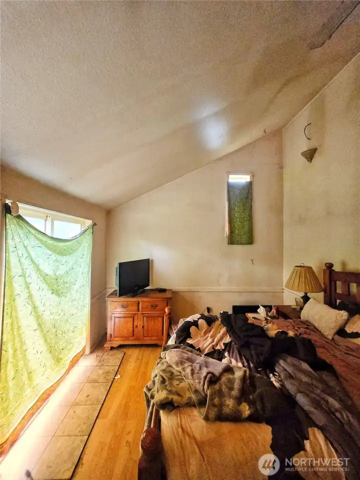 Primary bedroom with slider. Vaulted ceilings.