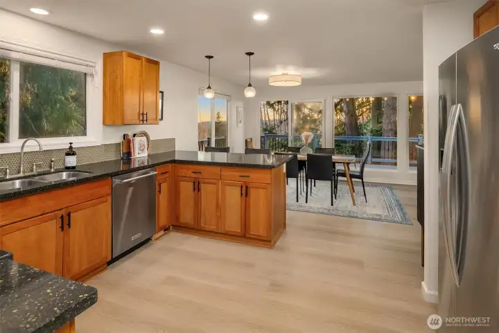 Spacious kitchen flows to dining and out to the deck with mountain views