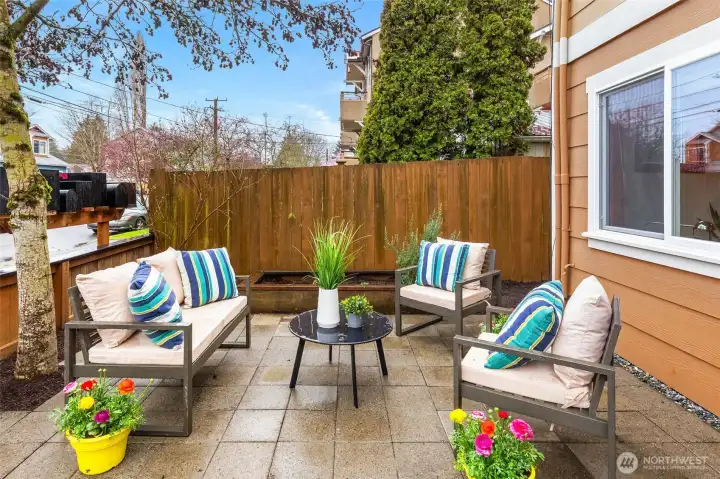 Adorable front yard with patio and garden bed- currently boasting rosemary, strawberries, and rhubarb