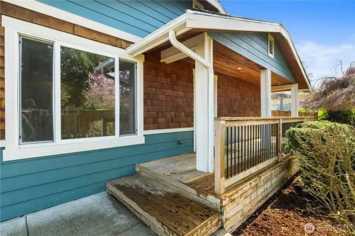 Inviting covered front porch with tongue-and-groove ceiling, cedar shake and cement plank siding.
