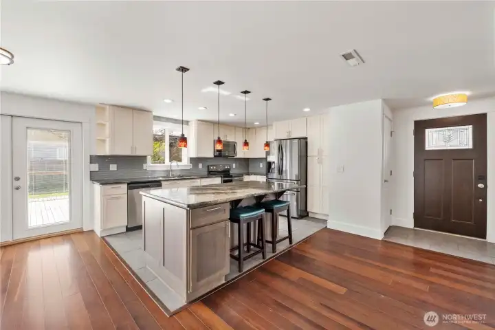 Chefs kitchen boasts gorgeous granite slab countertops with smooth bullnose edges and a chic tile backsplash.