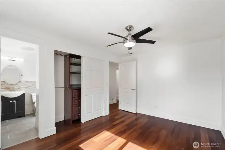 The primary suite features a ceiling fan and a closet with built-in storage.