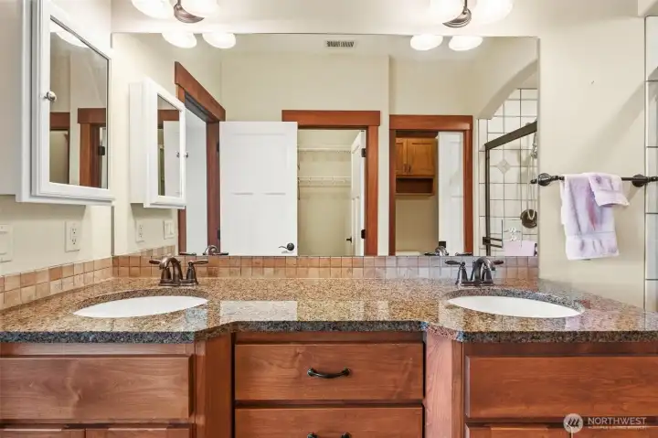 Primary Bathroom, double vanity, toilet with pocket door privacy, and a walk-in closet seen in reflection.
