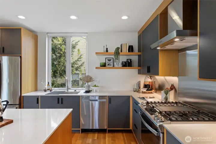 Additional kitchen features include: wide plank oak flooring, a tall opening window over the sink, under cabinet lighting, floating shelves and recessed LED lighting.