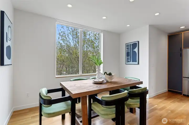 The dining room has a large picture window overlooking the greenbelt and custom window shade.