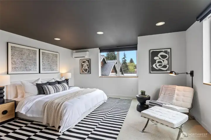 The huge primary bedroom has room for a King-sized bed, seating and dresser.