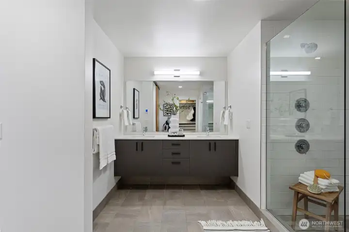 The primary bath has a floating double vanity with quartz countertop, undermount sinks and modern Moen fixtures.