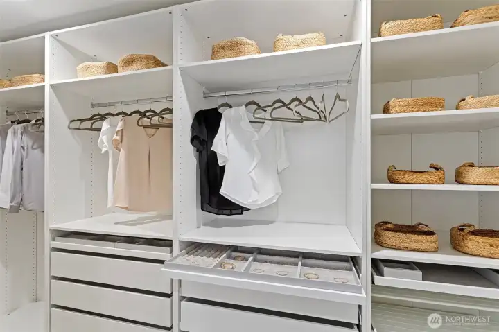 A huge walk-in closet / dressing room is outfitted with elaborate built-ins containing drawers, shelves, hanging space and even jewelry storage.
