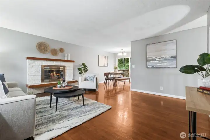 The cozy fireplace anchors this bright and inviting living room.