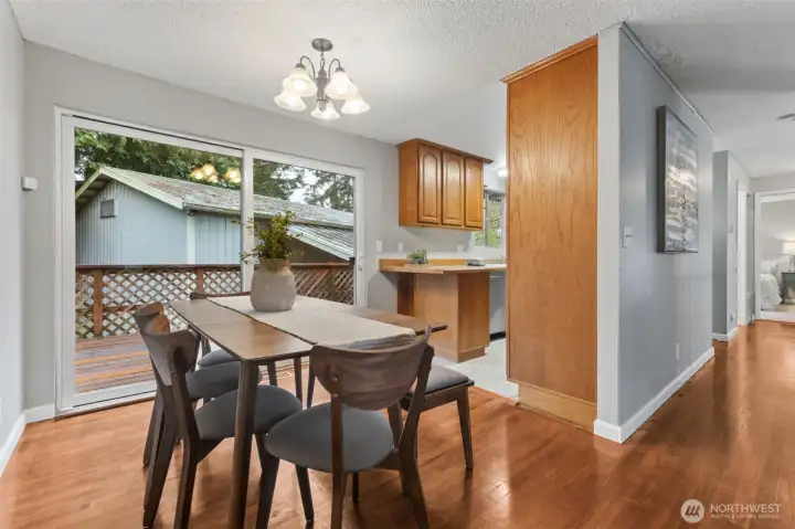Dining area with large windows overlooking the yard and easy kitchen access.