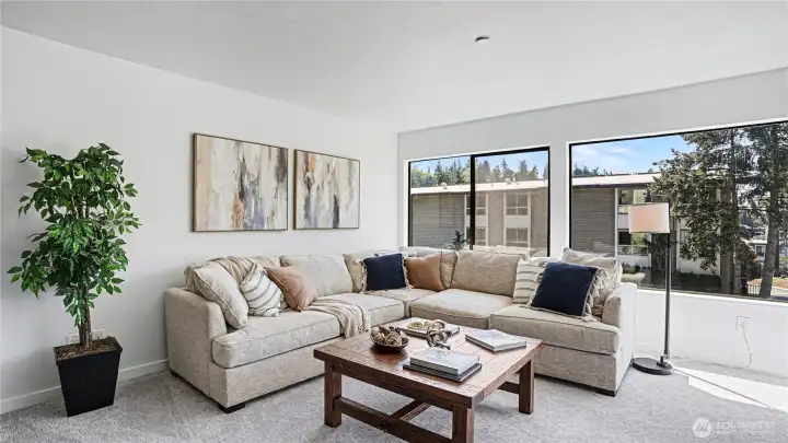 Brand new carpet and paint create a fresh, move-in-ready feel, while expansive corner windows fill the home with natural light.