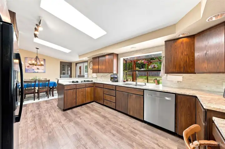 A roomy kitchen with a gas cooktop & downdraft hood fan A roomy kitchen with a gas cooktop & downdraft hood fan