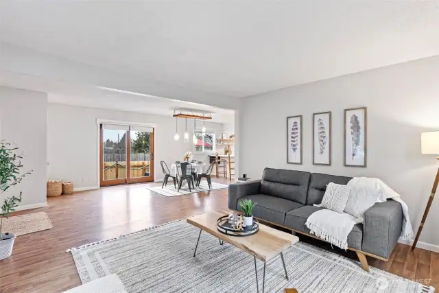 Looking back from the living room, there is an entry closest to the left and large dining area leading out to the deck and into the kitchen.