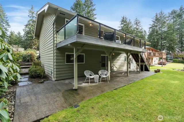 Back of home with deck and covered lower patio.